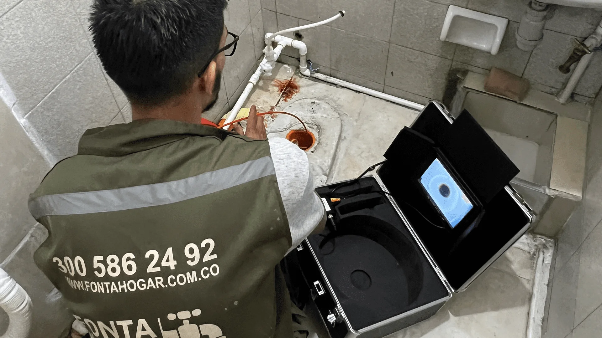 large-fonta persona inspeccionando una tuberia con camara