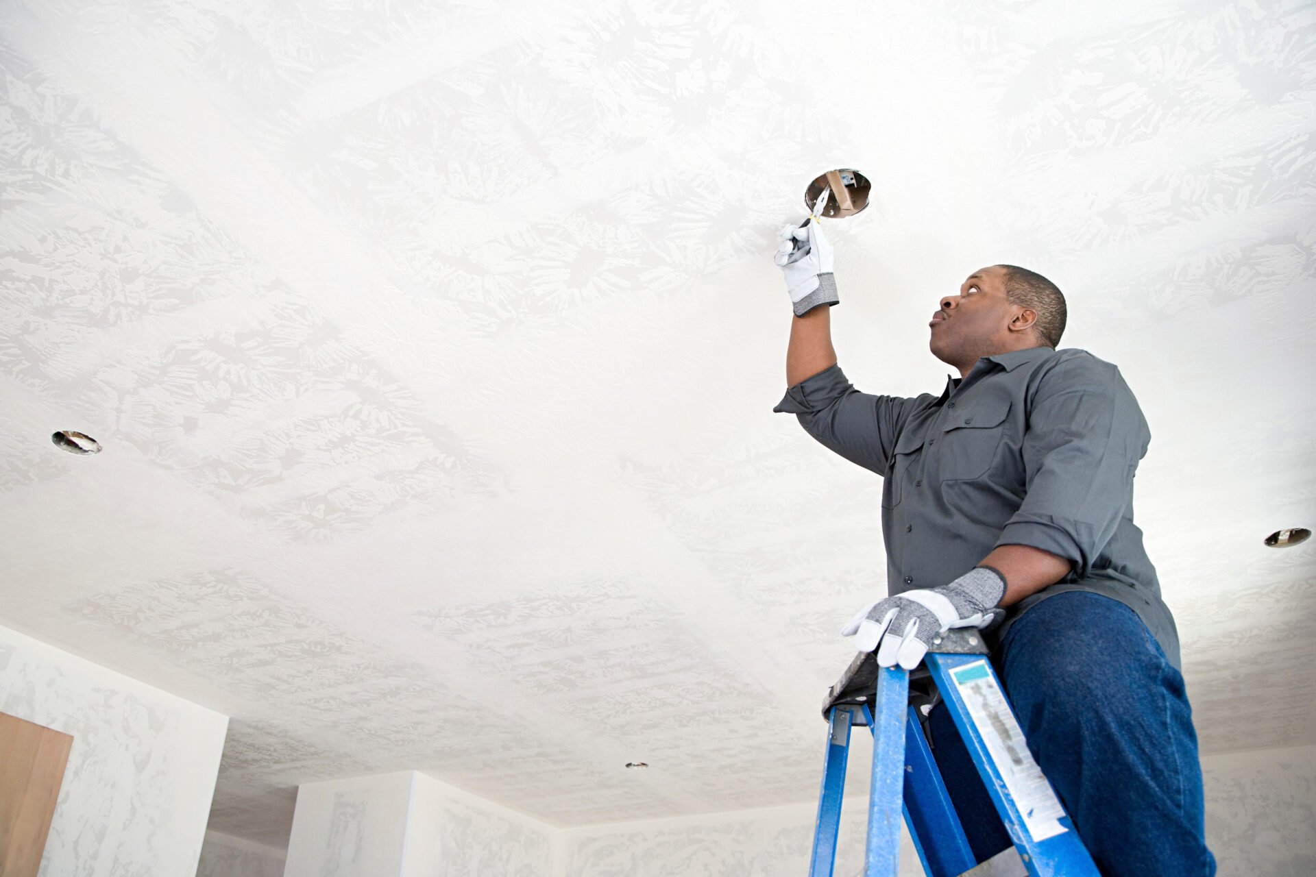 An electrician fixing wires Hombre instalando drywall